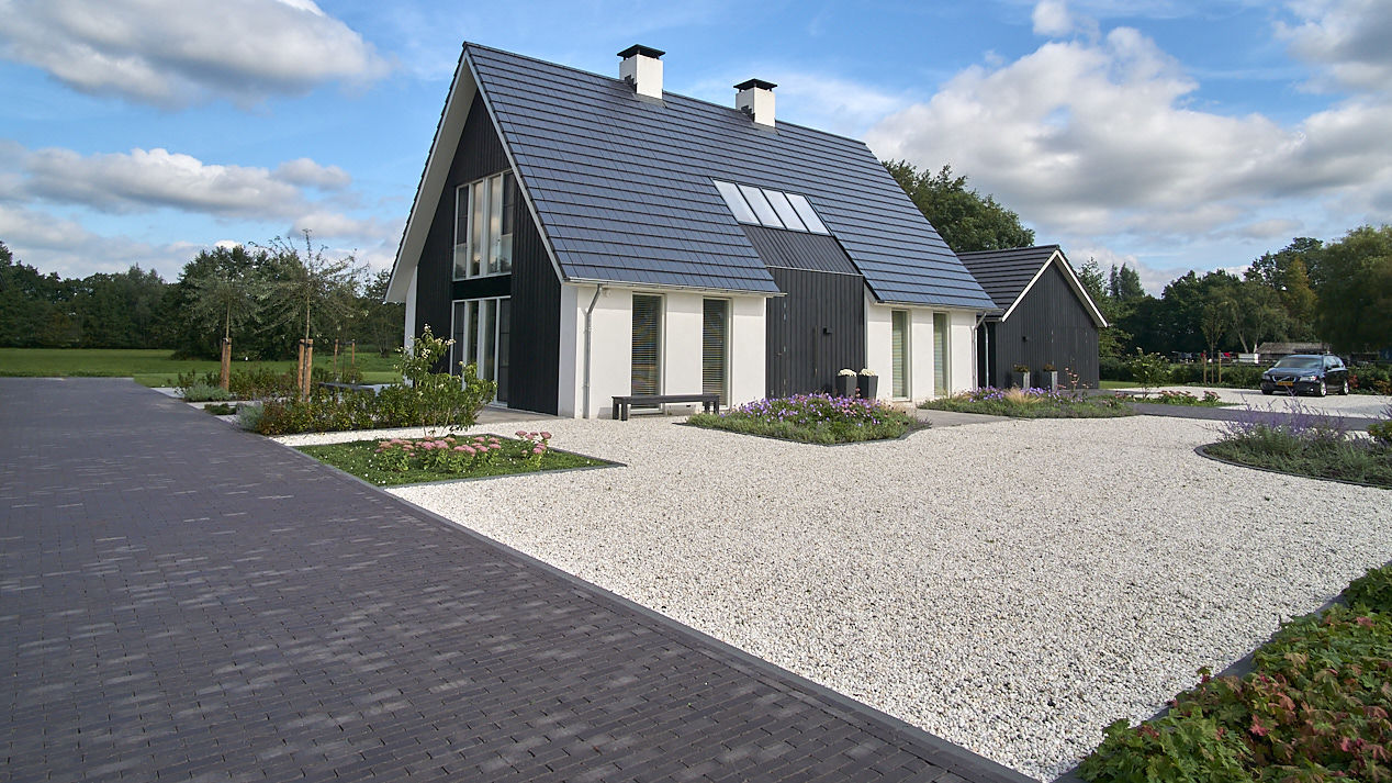 Stapstenen door een watertuin met siergrassen in Arlar